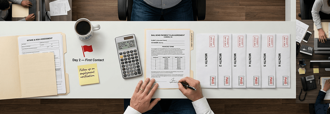 Bail bond agency installment agreement documents with payment schedule and signature lines on an office desk